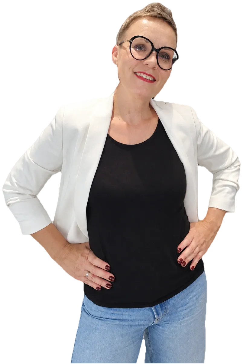 Marzena w białej marynarce stoi z rękami na biodrach, gotowa do działania