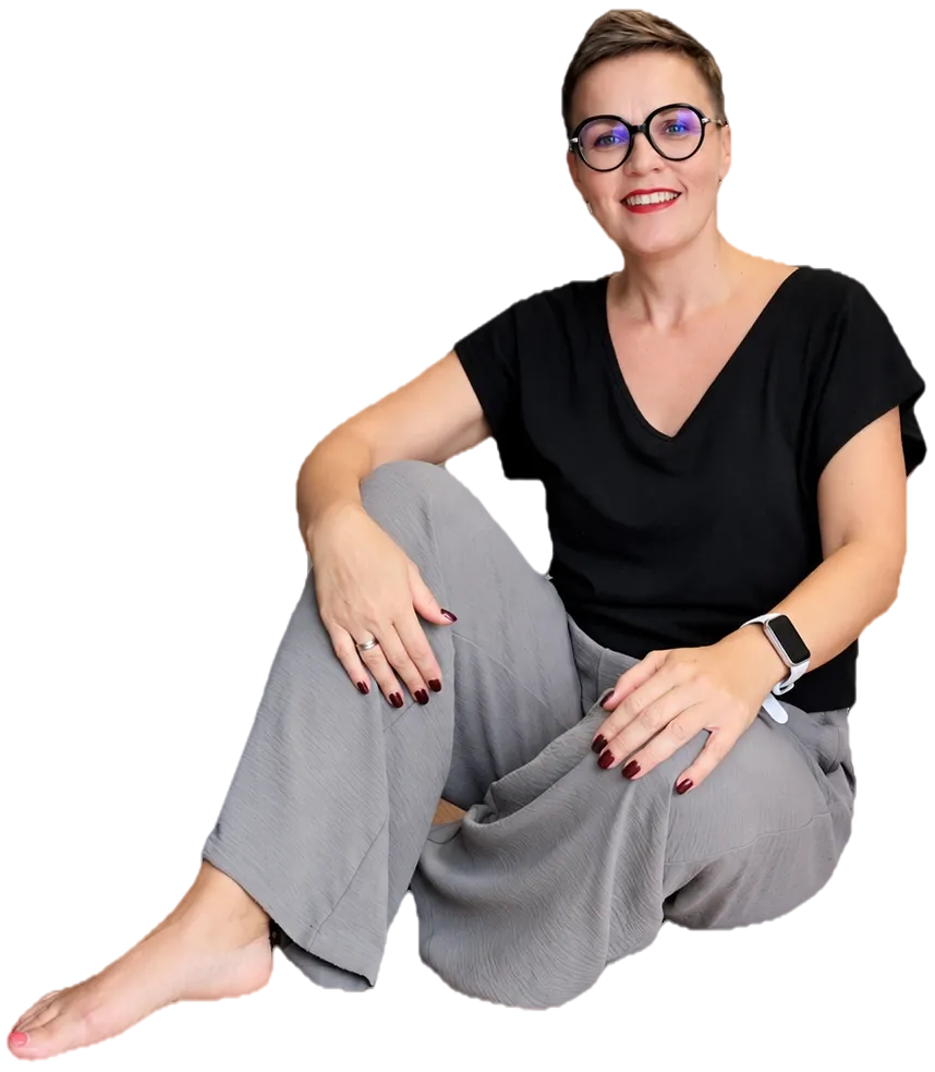 Marzena siedzi swobodnie na podłodze i się uśmiecha